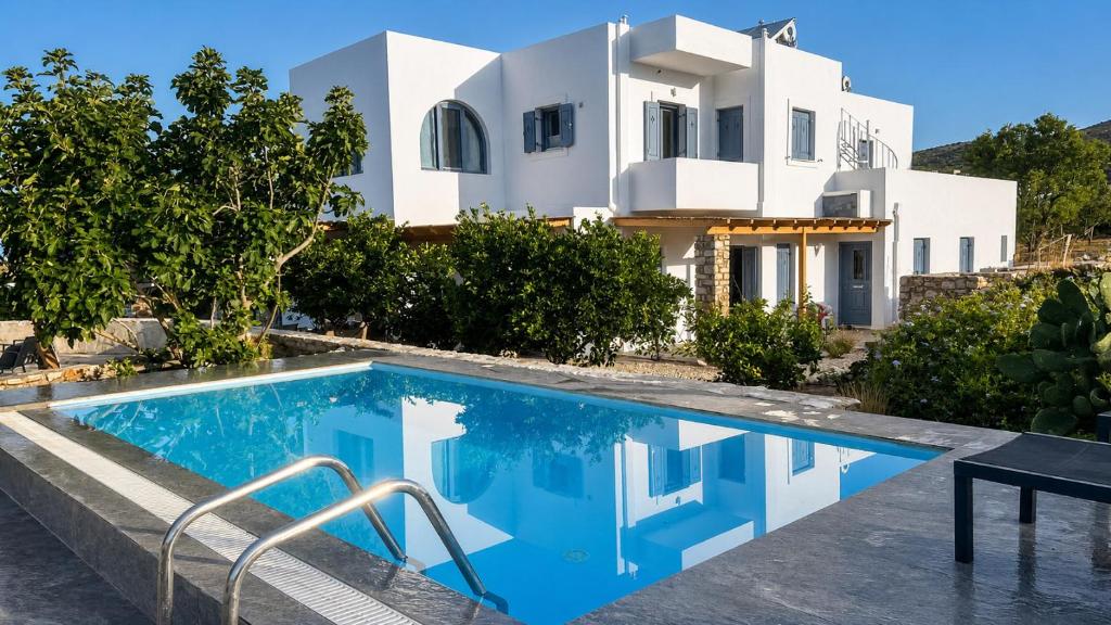a villa with a swimming pool in front of a house at La maison - Two Private Apartments, One with Private Pool in Angairiá