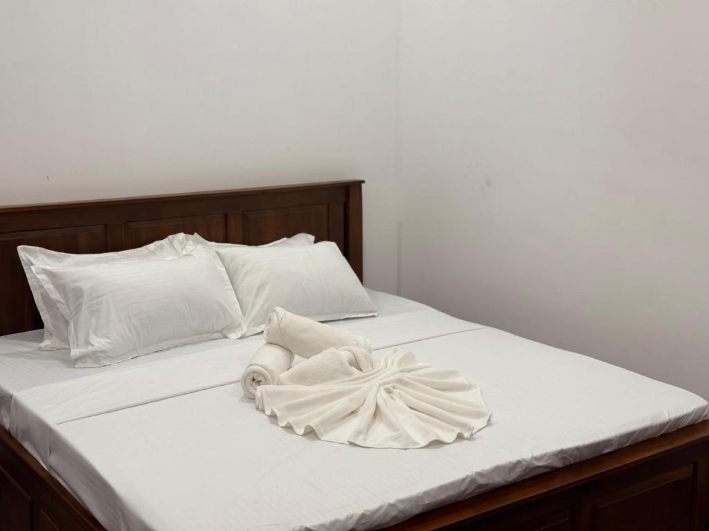 a white bed with white sheets and pillows at nama villa in Arugam Bay