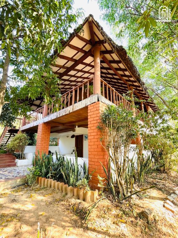 a brick house with a wooden roof at The Hideaway Hosur by evaddo stays in Hosūr