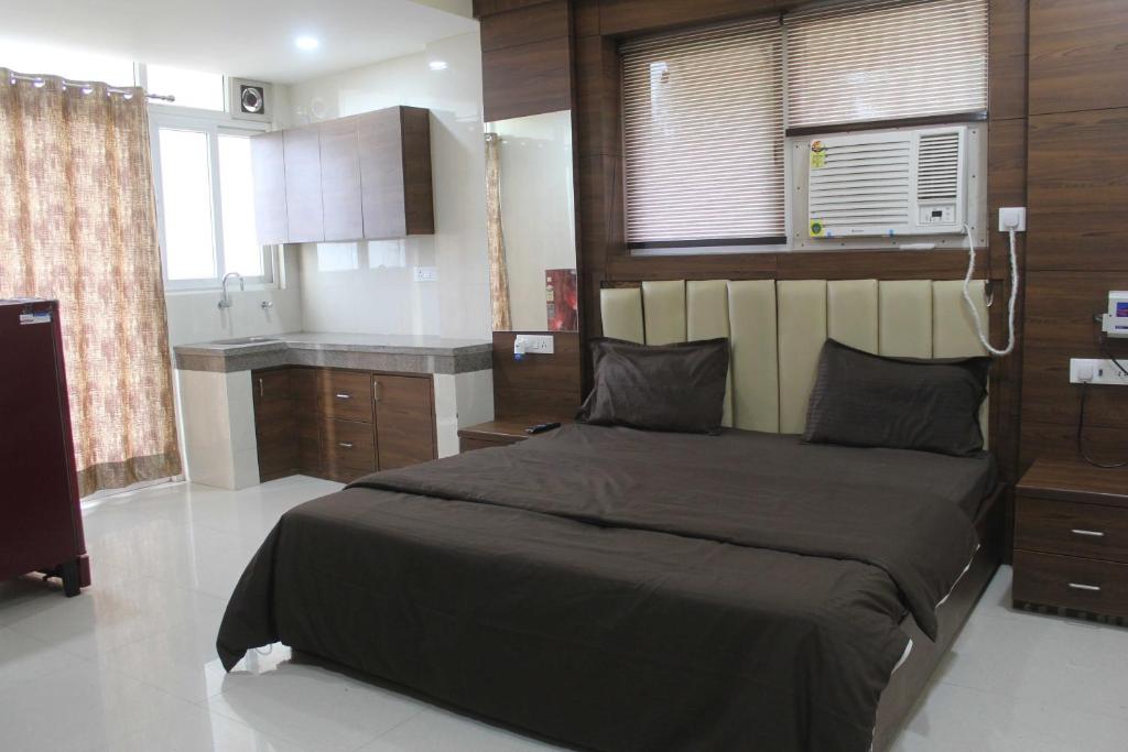 a bedroom with a large bed and a kitchen at Hotel O Daffodils in Gurgaon