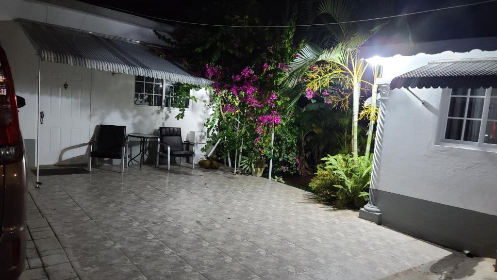 a patio with a table and chairs and flowers at Lorenton Hideaway Studio in Lucea