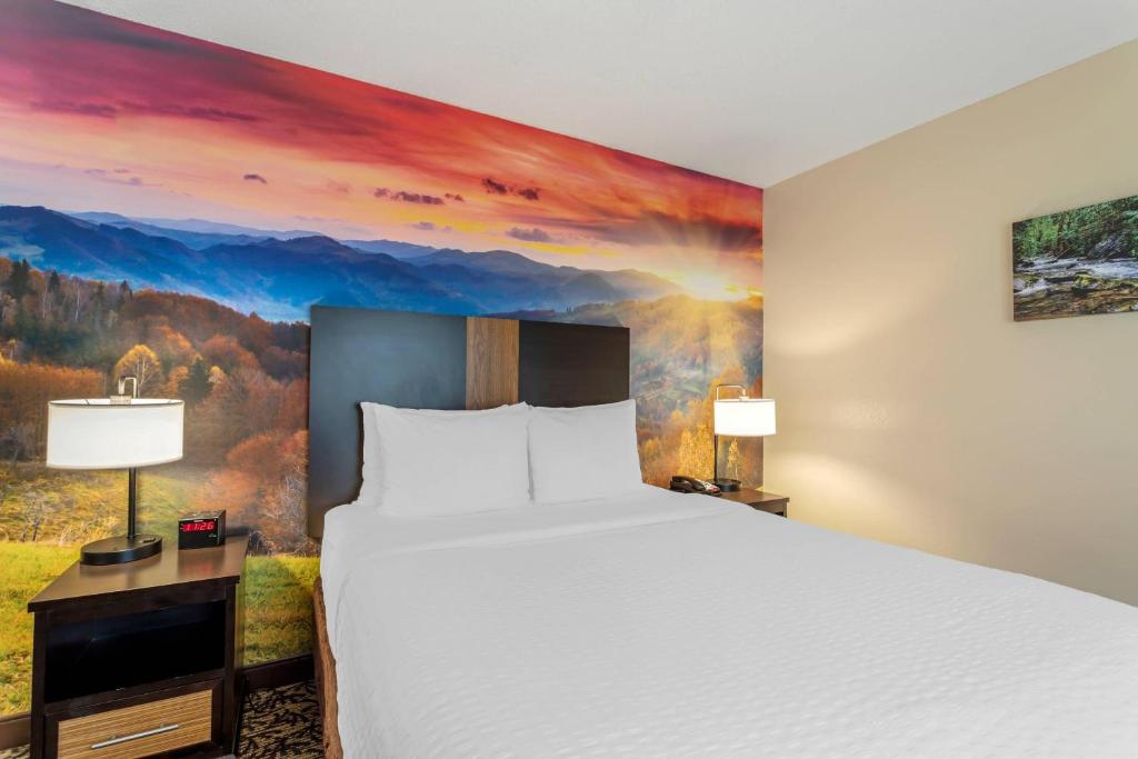 a hotel room with a bed and a painting at LeConte Hotel & Convention Center, an Ascend Collection Hotel in Pigeon Forge