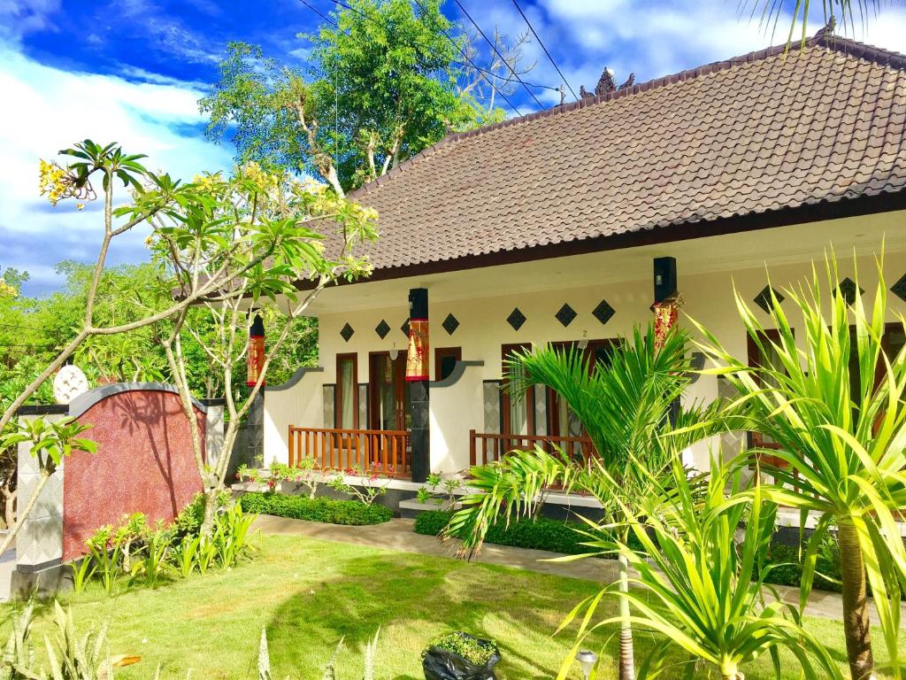 una casa con un jardín delante de ella en Nusa Garden Homestay, en Nusa Lembongan