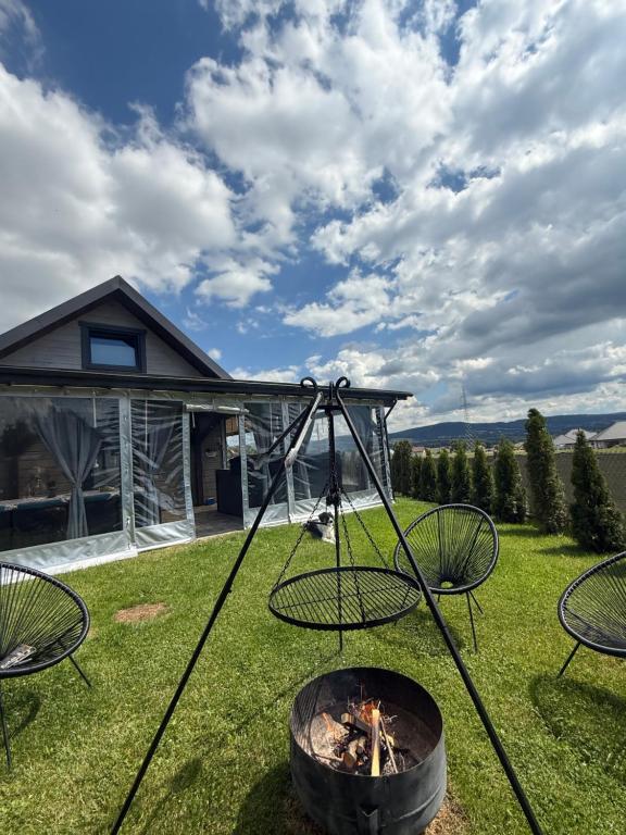a backyard with a fire pit and chairs and a house at Domek w Kobylance in Kobylanka