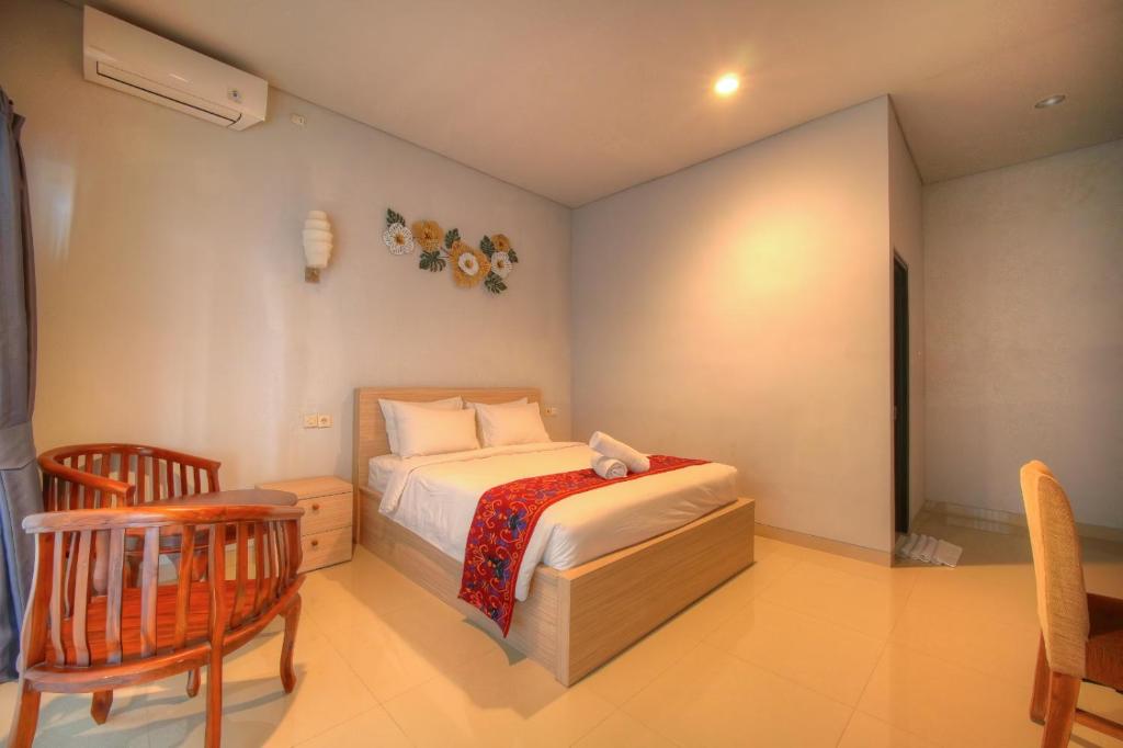 a bedroom with a bed and a table and chairs at The Joy Rooms Penida in Nusa Penida