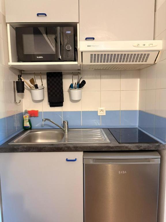 a kitchen with a sink and a microwave at Le Clos d'AIX studio 305 in Aix-en-Provence