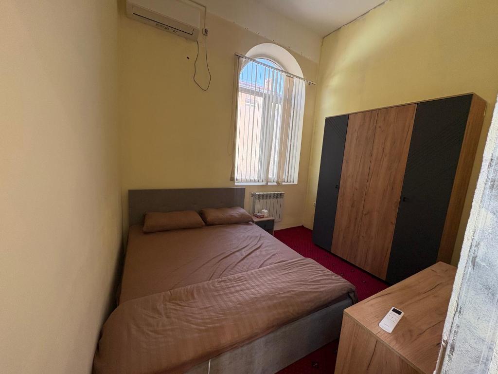 ein kleines Schlafzimmer mit einem Bett und einem Fenster in der Unterkunft Ruma Hotel in Yerevan