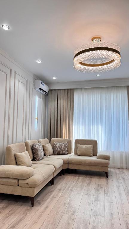 a large living room with a couch and a chandelier at High Town City in Lunacharskiy Bekati