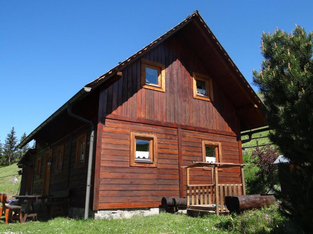 a large wooden cabin with a gambrel roof at Jakobihütte in Sankt Margarethen bei Knittelfeld