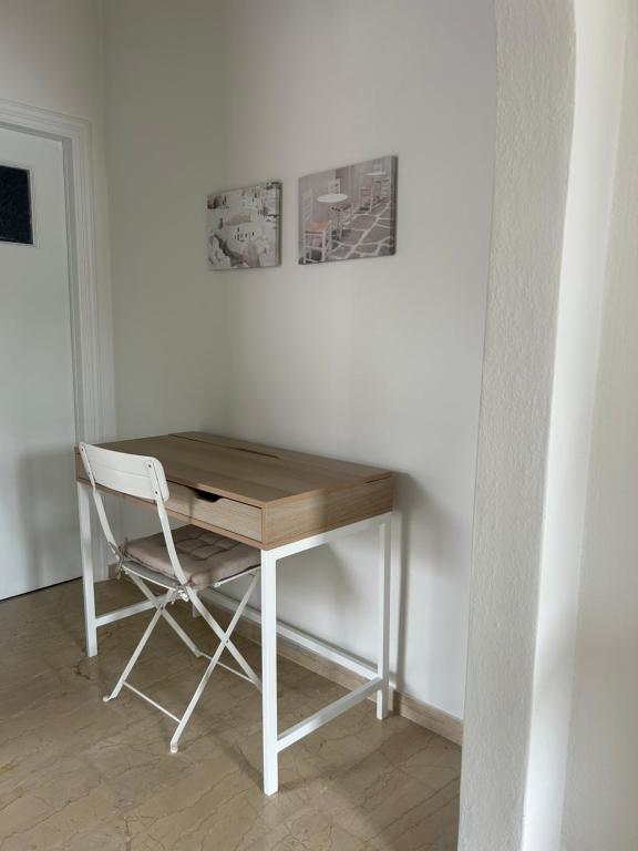 a wooden desk with a chair next to a wall at Anna Coast Apartment in Agia Anna