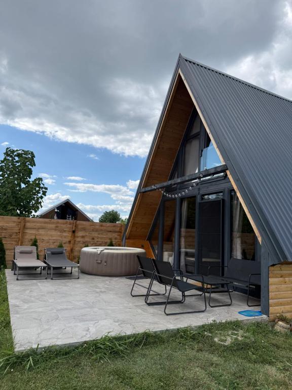 a house with a metal roof and chairs on a patio at La Madera in Stanica Rumenka