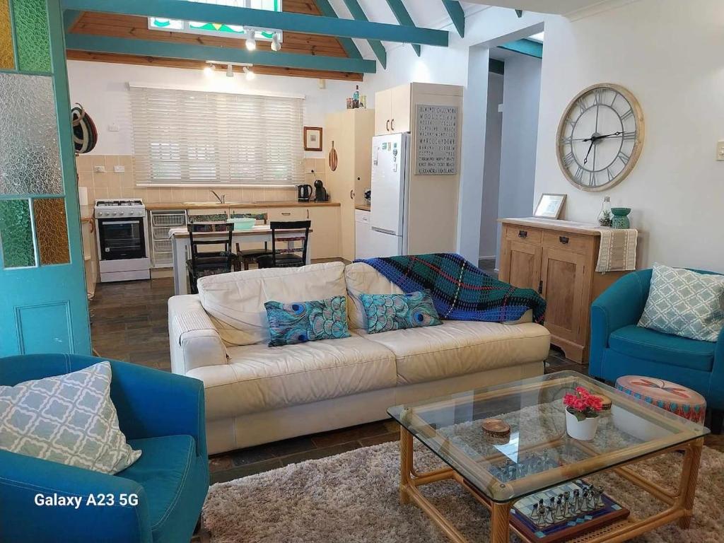 a living room with a couch and a table at Alba the Scots Cottage walk every where in Maleny