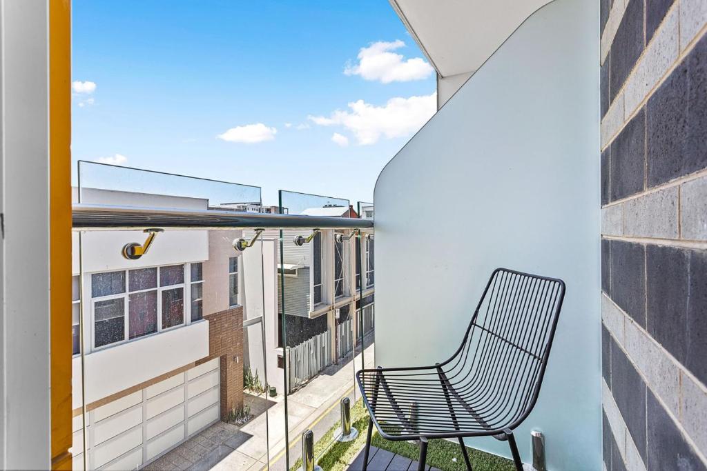 a chair sitting on the balcony of a building at Nest on Newcastle - E3 in Perth