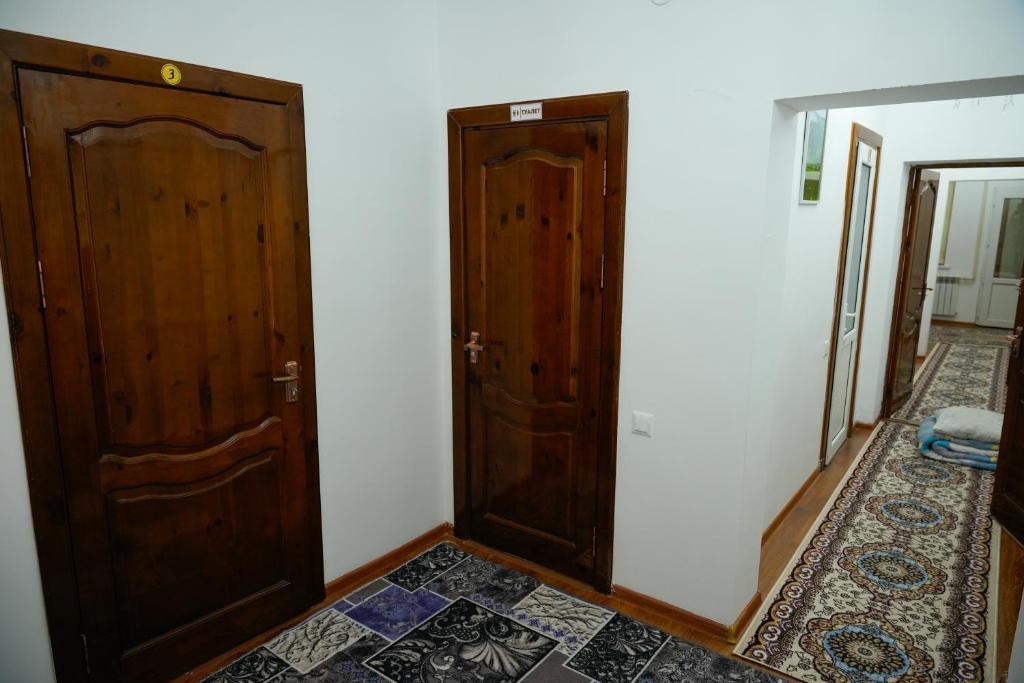 a room with two wooden doors and a tile floor at Meyman House in Karakol