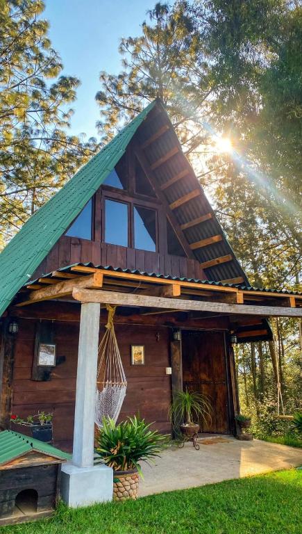 a log cabin with a green roof at Sp Atmatla Zacatlan Cabins in Zacatlán