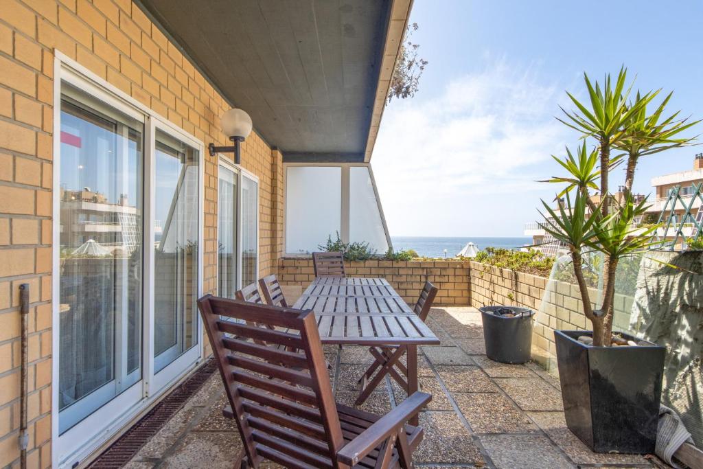 a patio with a table and chairs and the ocean at Beach Sunset - Apartment Ocean in Vila Nova de Gaia