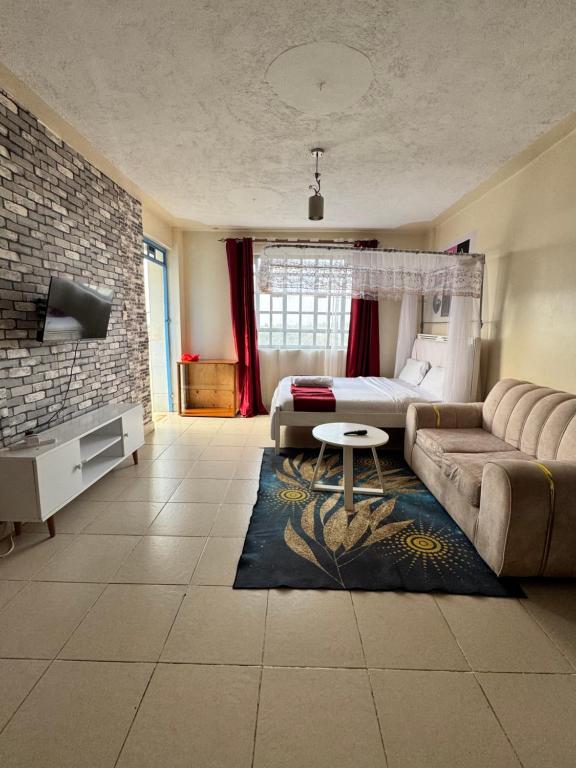 a living room with a couch and a bed at The Homely Retreat in Thika