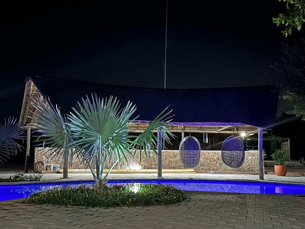 a night view of a building with blue lights at Siki's Cactus Hideaway in Mmokolodi