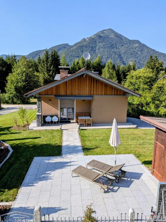 a house with a patio and a table and an umbrella at Chalet Ausweger - Strobl am Wolfgangsee in Strobl