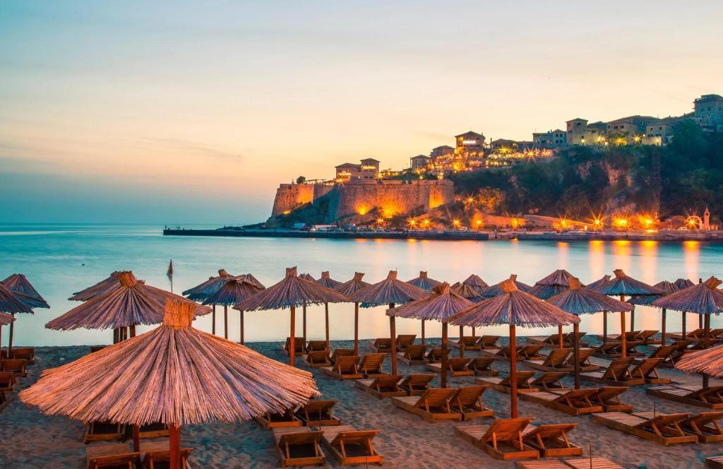a group of beach chairs and umbrellas on a beach at Apartments Lazo in Ulcinj