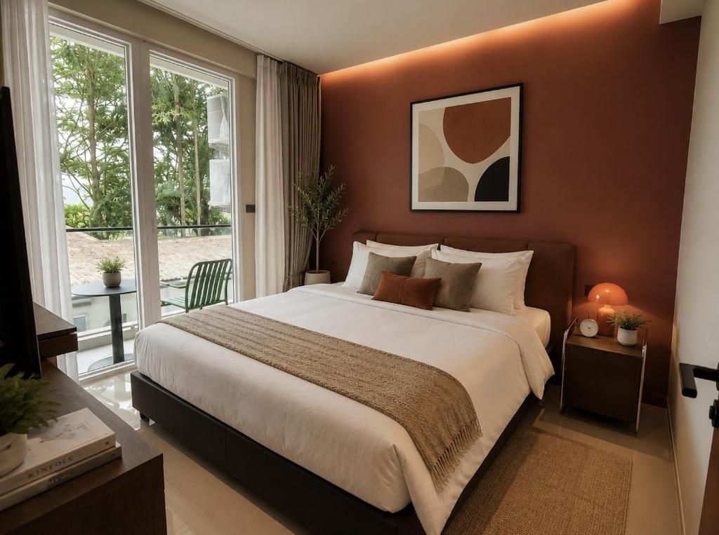 a bedroom with a large bed and a large window at Syama Mansion Kamala in Kamala Beach