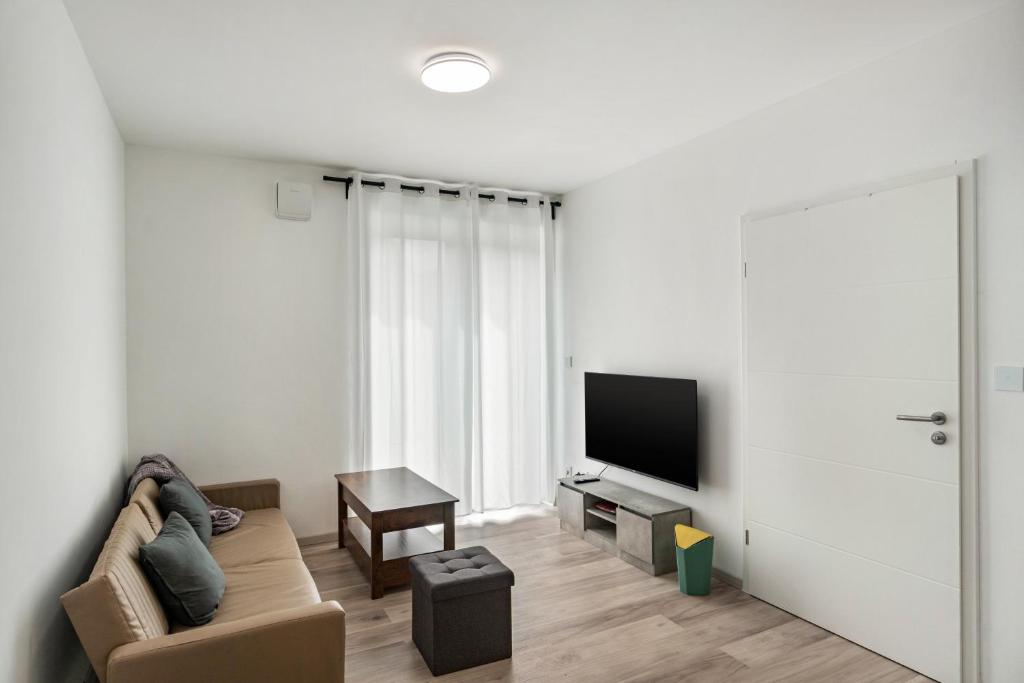 a living room with a couch and a flat screen tv at Haus Seeluft - W3 in Butjadingen