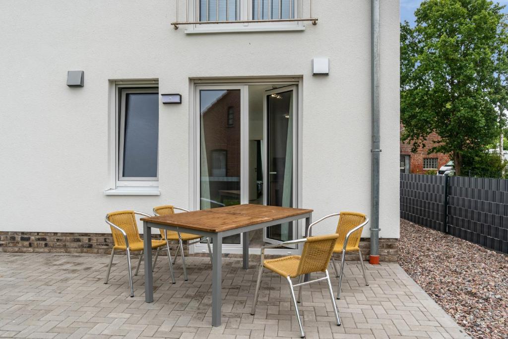 a table and chairs on a patio in front of a house at Haus Seeluft - W1 in Butjadingen