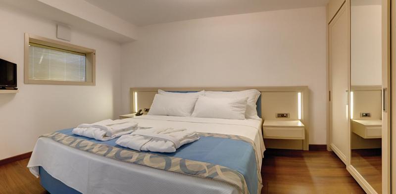 a bedroom with a large bed with towels on it at Heykel Suites Otel in Konak