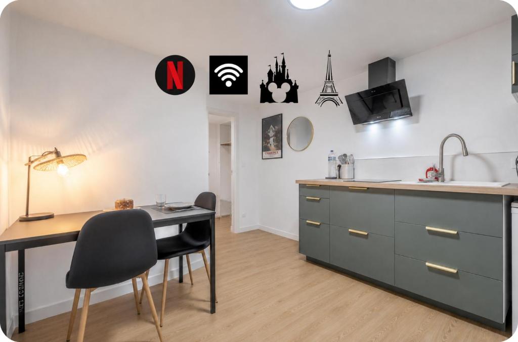 a kitchen with a desk and a table with chairs at Studio élégant en RDC, confort et simplicité in Vaires-sur-Marne