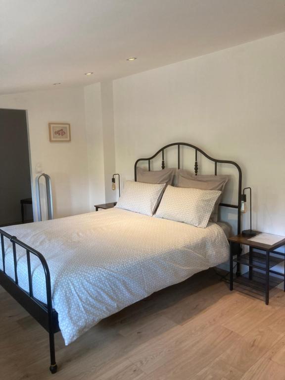 a bedroom with a large bed and a side table at Atelier chambres in Semur-en-Auxois