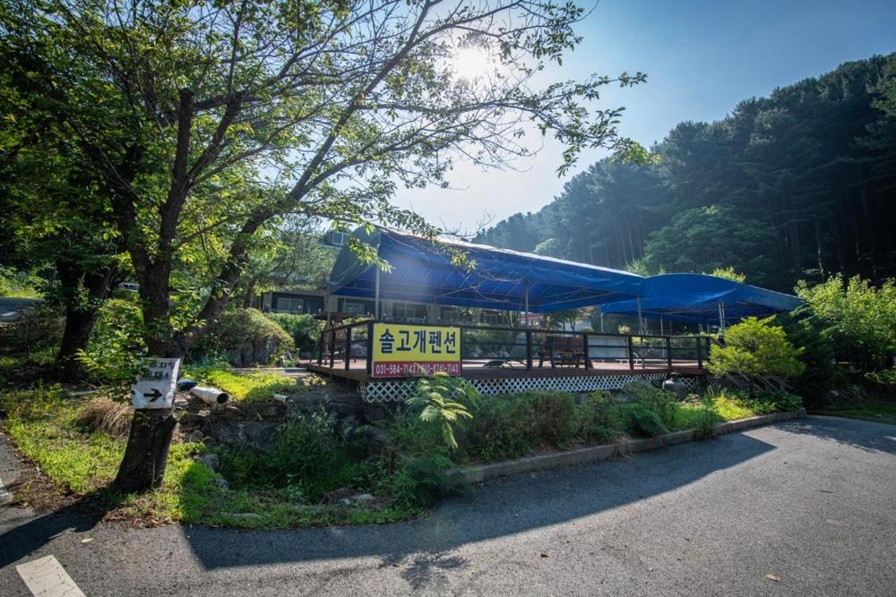 a building with a blue tent in a parking lot at Gapyeong Solgogae Pension in Gapyeong