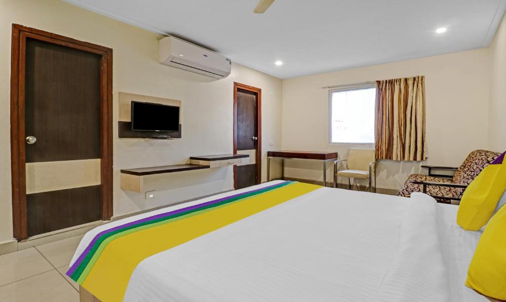 a hotel room with a large bed and a tv at Hotel G Square in Vijayawāda