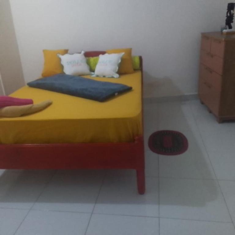 a bedroom with a yellow bed with pillows and a dresser at VILLA Moissuli maison entière confortable avec Starlink in Mtsamboro