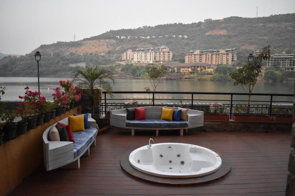 a bath tub on a deck with a view of the water at Lavasa Lake Palace in Lavasa
