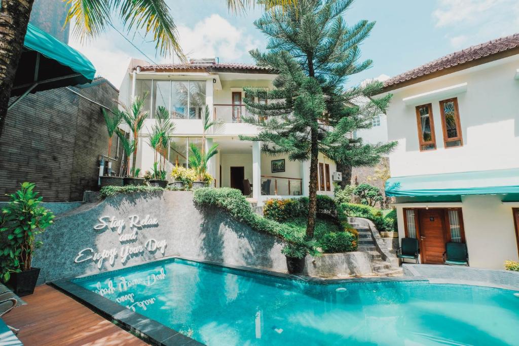 a swimming pool in front of a house at Aleyra Hotel and Villa's Garut in Garut