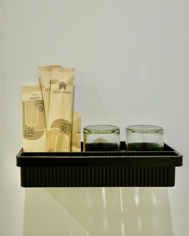 a black shelf with two candles and two glasses at Lê Gia Homestay 2 in Hue