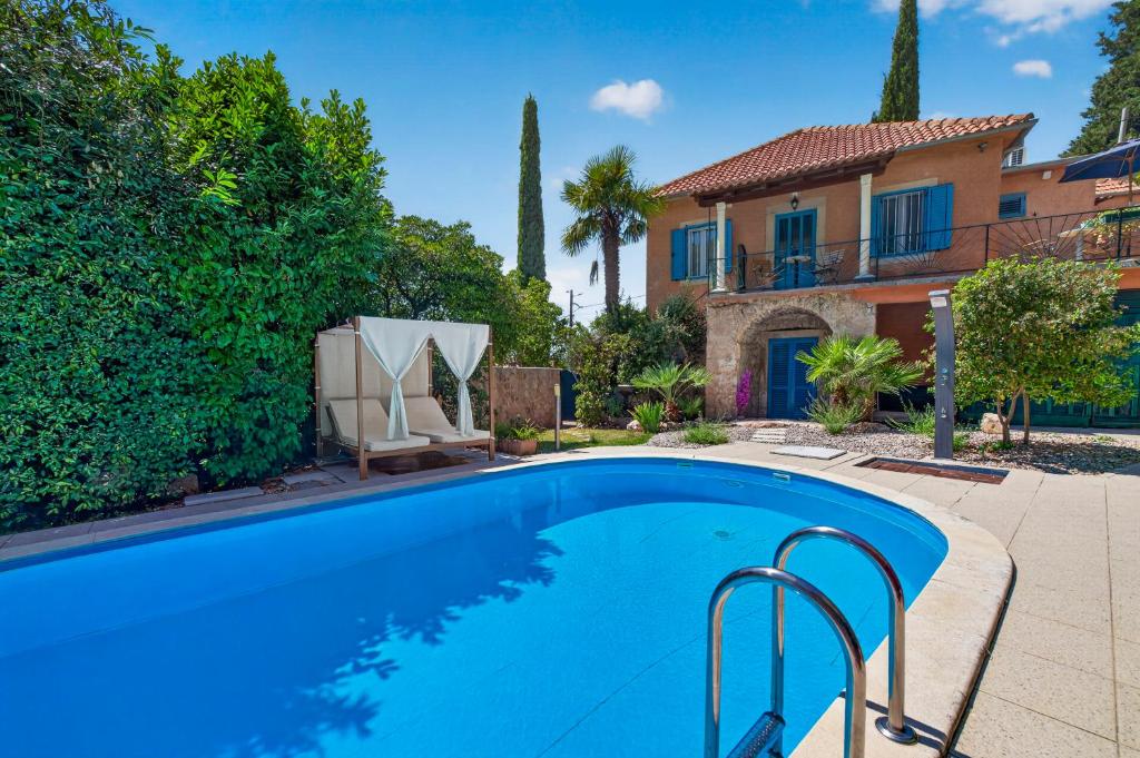 a swimming pool in front of a house at Villa Balic in Gruda