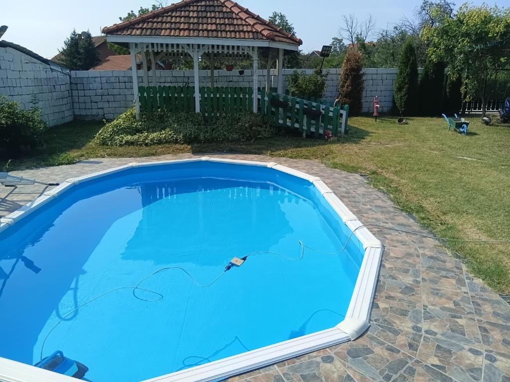 a large blue swimming pool with a gazebo at Rankine Kolibe in Kladovo