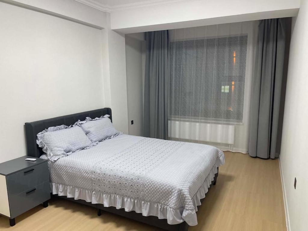 a white bedroom with a bed and a window at Amarida residence in Erdenet