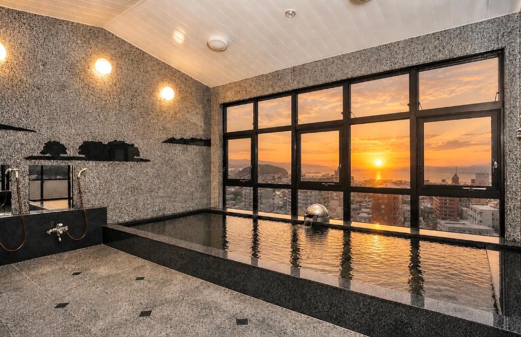 a swimming pool in a room with a sunset view at Matsue Universal Hotel in Matsue