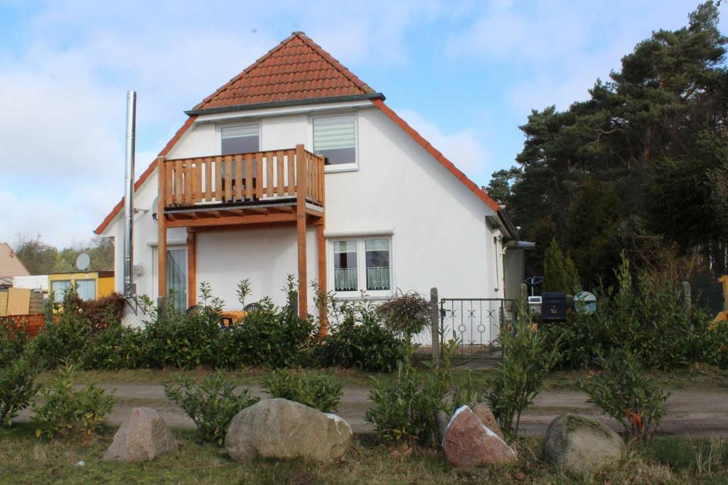 a white house with a porch and a deck at Ferienwohnungen am Wald in Lütow