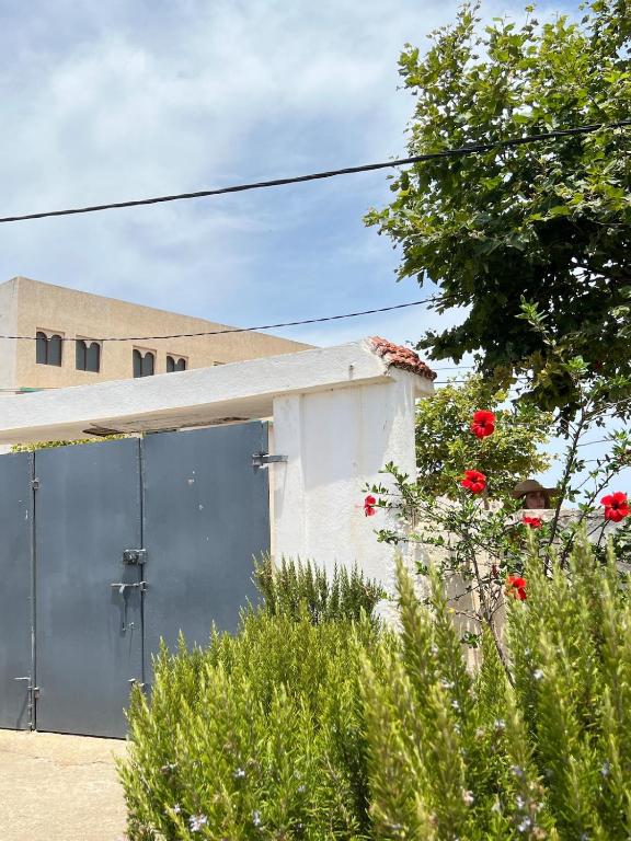 a building with a garage with red roses in front of it at Relax in Oued Laou in Oued Laou