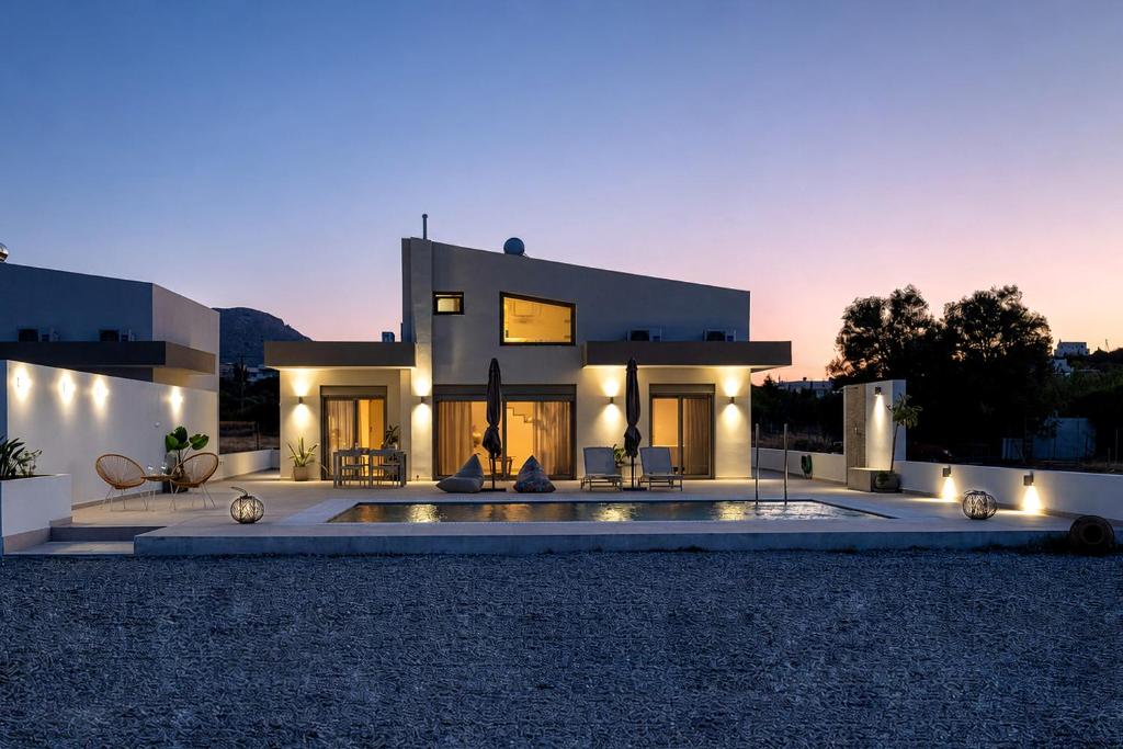 a large house with a swimming pool in front of it at Azzurro Luxury Villas in Kolymbia
