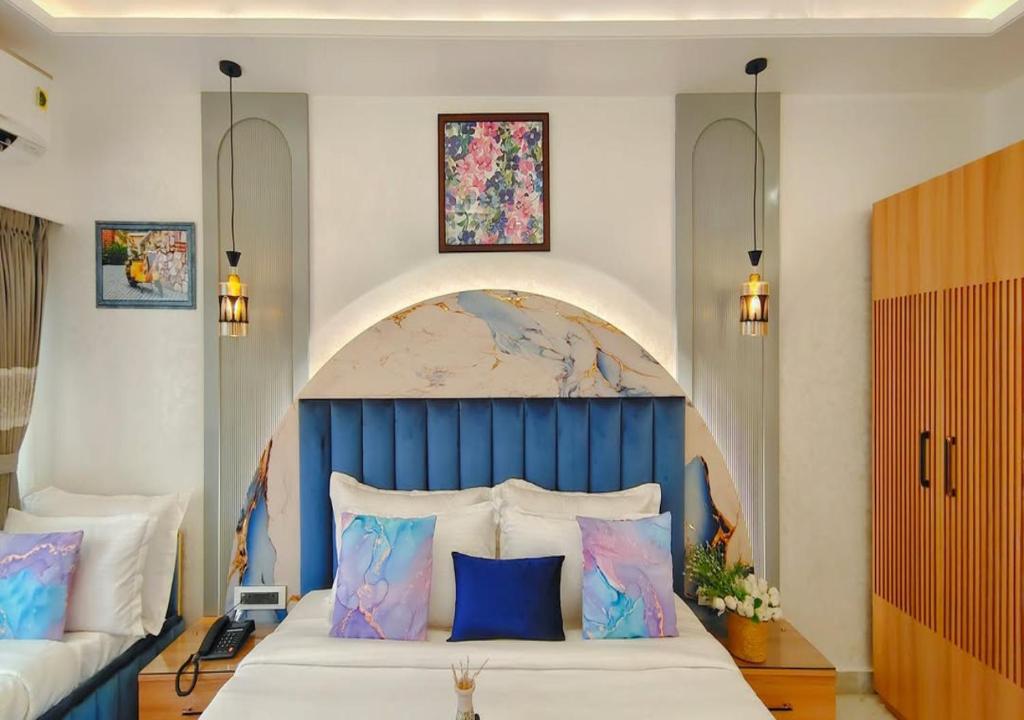 a bedroom with a large bed with a blue headboard at Atlantiis Suites By Signature StayZ Girjaghar Near Vishwanath Temple in Varanasi