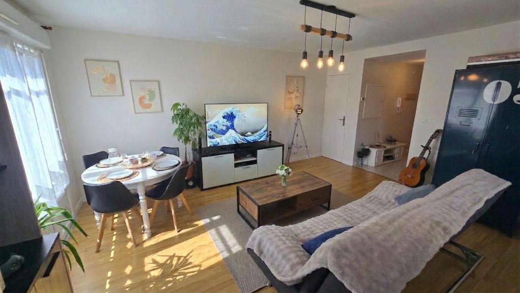 a living room with a couch and a table at Appartement, Calme, Cosy et Balcon in Châteauroux