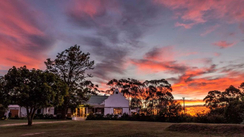 a house with a sunset in the sky at Skeiding Guest Farm in Heidelberg