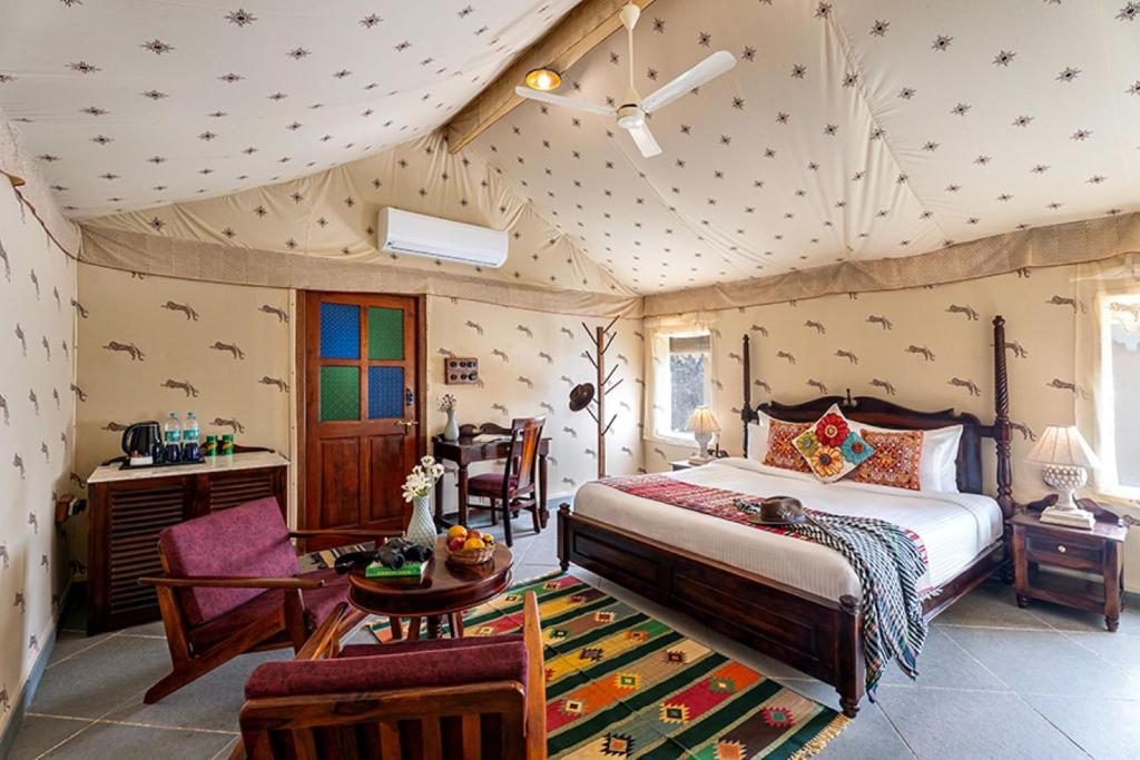 a bedroom with a bed and a table and chairs at Sam Sand Dunes Camps Jaisalmer in Sām