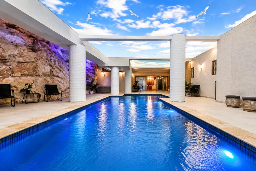 a swimming pool in a house with columns at וילה לוזון - וילה מדהימה עם בריכה פרטית מחוממת ומקורה בכרם בן זמרה in Kerem Ben Zimra