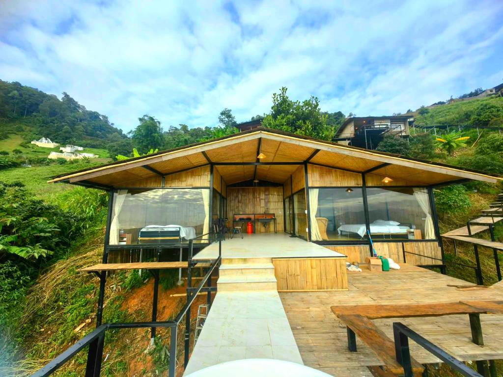 a house on a hill with a deck and a table at Mon Ngo misty haven B4 in Ban Mae Ta Man