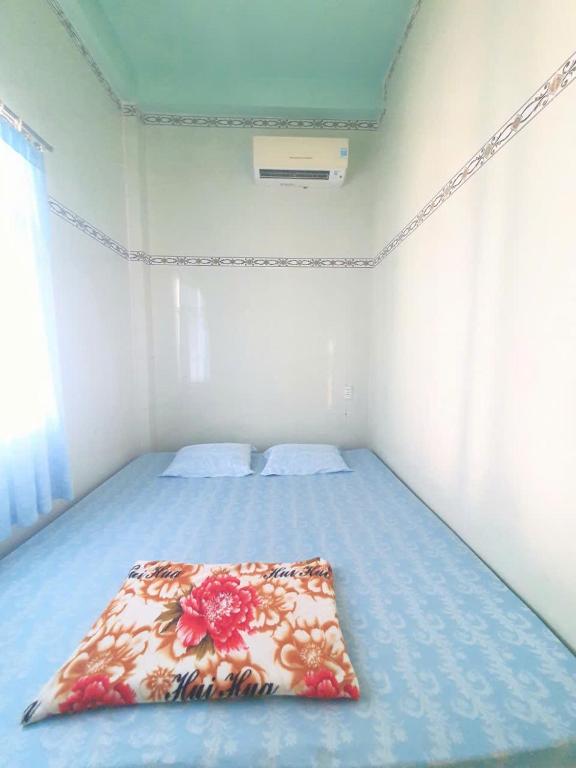 a bedroom with a blue bed with a blanket on it at Đào Huỳnh Motel in Nam Du